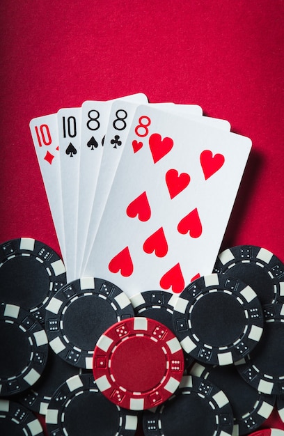 勝つポーカーの組み合わせはフルハウスまたはフルボートです。ポーカークラブの赤いテーブルのチップとカード