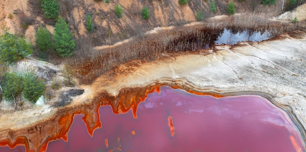 Winning van ertsen van verschillende metalen. Rood giftig water in het reservoir van de mijnbouw- en verwerkingsfabriek. Drone-weergave.