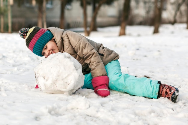 Winter actieve vakantie spelen in snowpark Kind sneeuwbal leuk maken en in de sneeuw liggen