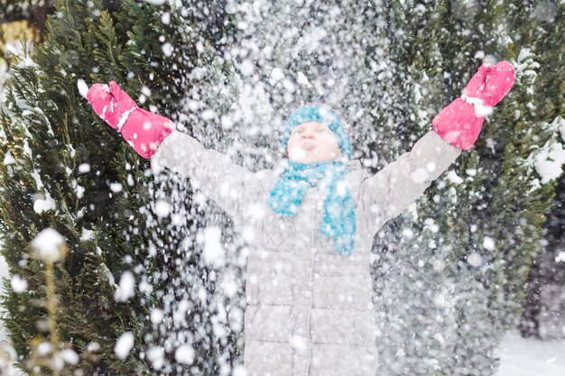Winter active holidays Activity children walking in snow winter park Girl throws snow