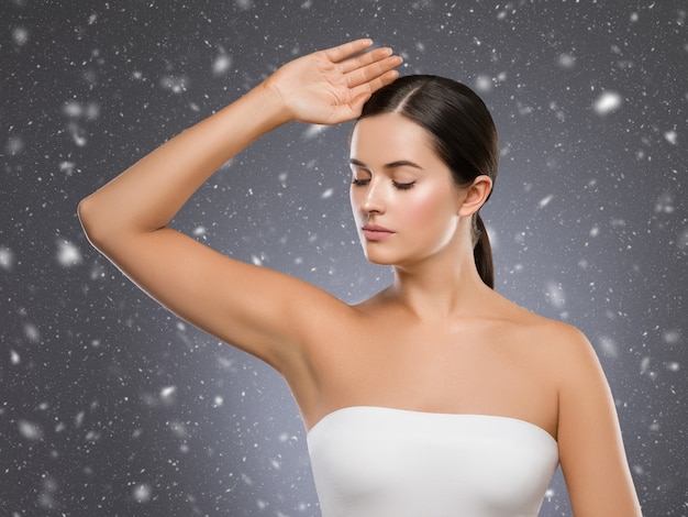 Winter armpit woman winter concept snowflakes background woman hand up beauty depilation. Studio shot.