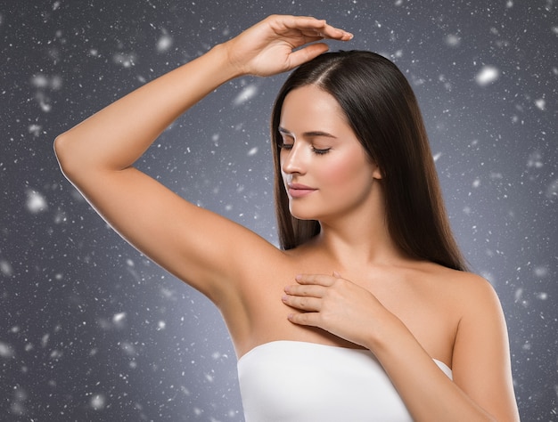 Winter armpit woman winter concept snowflakes background woman hand up beauty depilation. Studio shot.