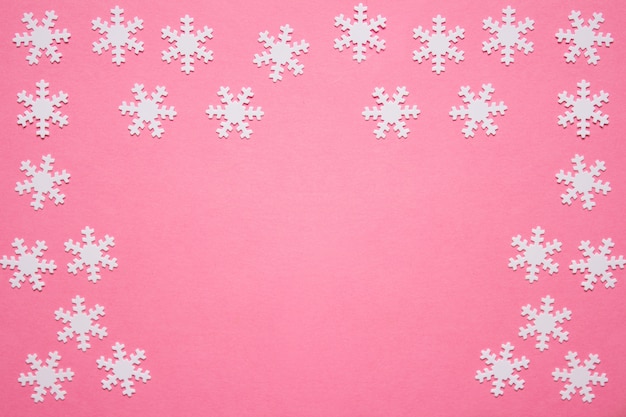 Winter backgound with snowflakes on pink 