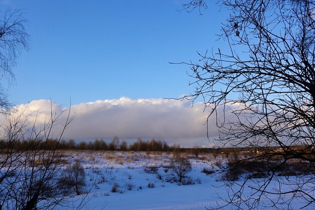 冬の背景。川は氷で覆われています。大きな雲と青い空。ロシア。