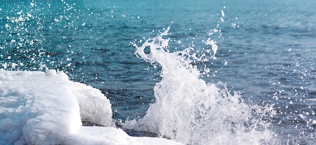 写真 氷の海岸を打つ波と冬の背景