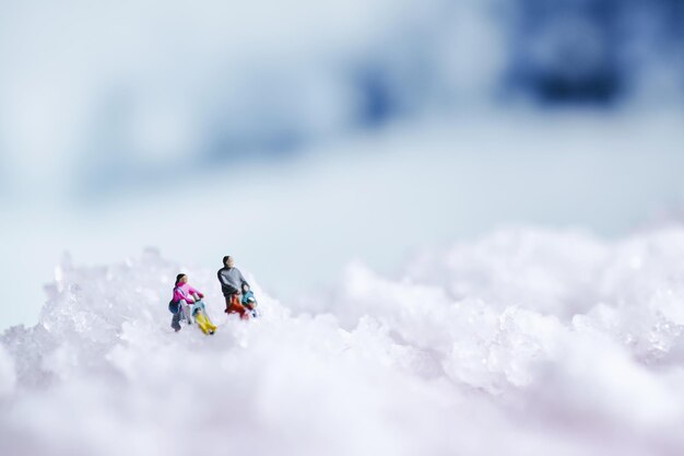 Winter background with snow texture and miniature people