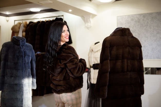 Winter beautiful Woman in Fur Coat. Beauty Fashion Model Girl In a Fur Store.