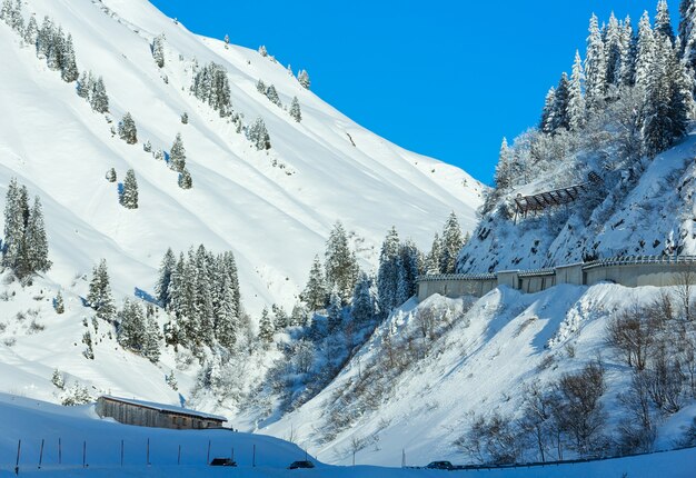 Winter berglandschap met besneeuwde spar en weg op helling (Oostenrijk, Tirol).