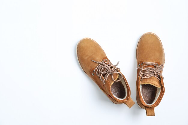 Winter boots on white background, top view