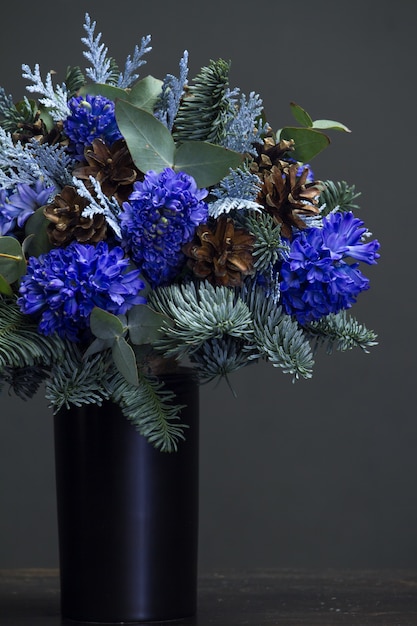 Winter bouquet of blue hyacinths and cones