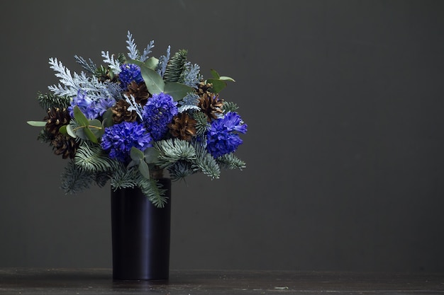 Winter bouquet of Nobilis fir twigs, blue hyacinths and cones, winter concept