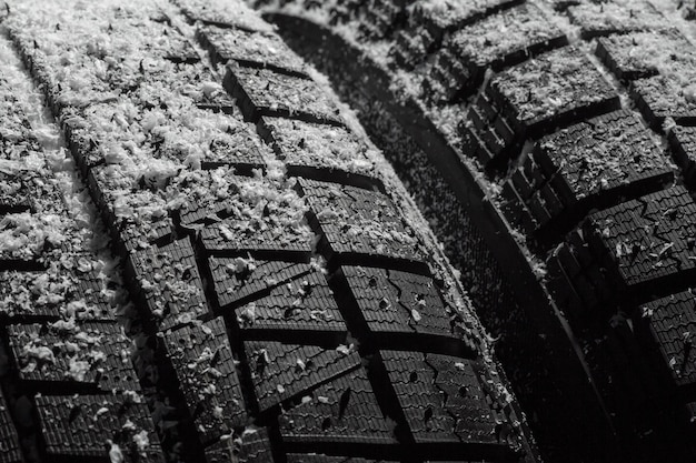 Winter car tires with snow closeup wheel profile structure on black background