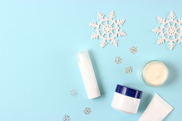 Winter care cosmetics on a colored background top view