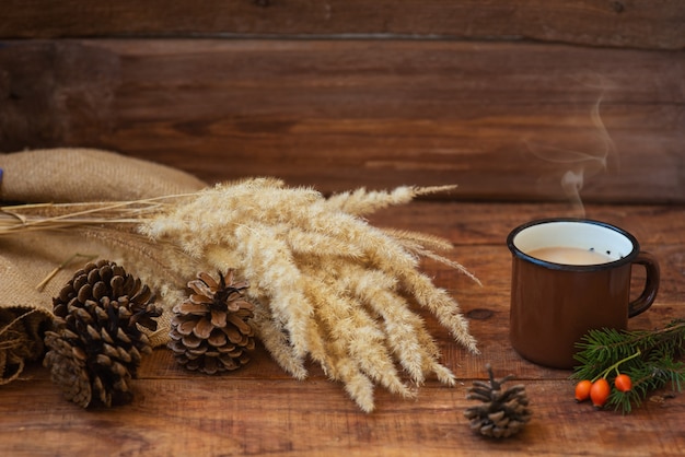 Winter, Christmas background in rustic style. A metal vintage mug with hot milk tea stands on a tablecloth