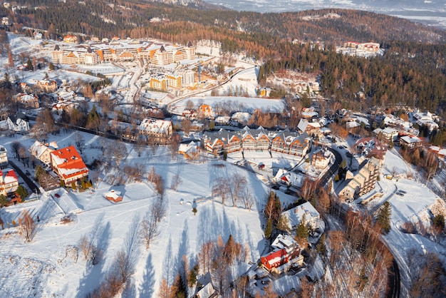 山の森に囲まれた冬の街。ドローンからの冬の風景の眺め。カルパチ。ポーランド