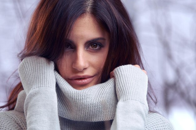 Foto prossimo piano invernale e ritratto di donna per la moda con maglia a collo di tartaruga e cima calda da albero in natura persona femminile signora messicana e ragazza di generazione z con il viso per abiti di stile e freddo nella neve