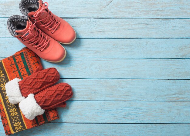 Winter clothes and shoes on a wooden background