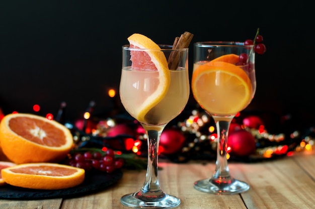 Winter cocktail with grapefruit, cinamon and red currant in wine glasses.