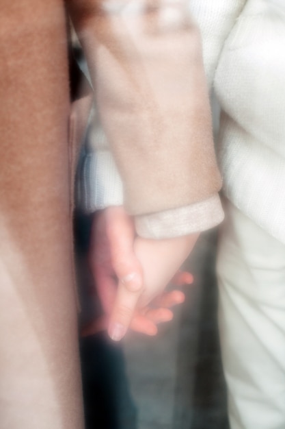 Photo winter cold weather closeup of young couple in love hands holding each other