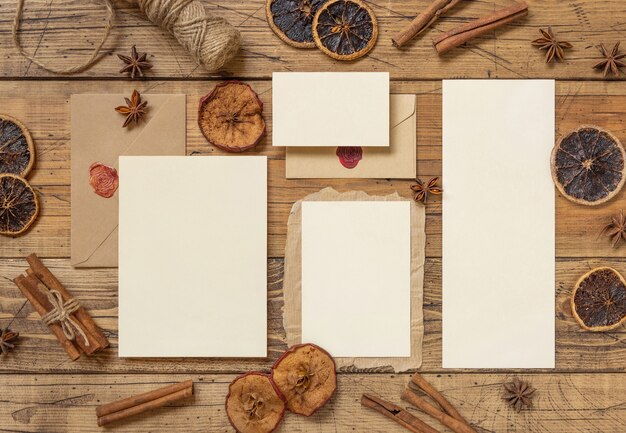 Foto composizione invernale con una busta sigillata in carta bianca spezie e frutta secca su tavola di legno