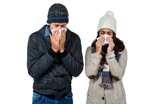 Winter couple blowing their noses