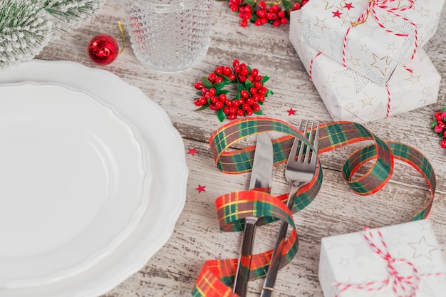 Winter couvert met kerst- en Nieuwjaars versieringen op witte houten tafel. Feestelijke tafelsetting voor het kerstdiner.