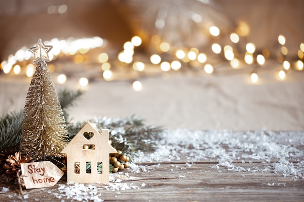 Winter cozy  festive decor details, snow on a wooden table and bokeh. stay home