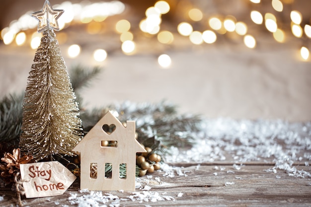 Winter cozy wall with festive decor details, snow on a wooden table and bokeh. Stay home concept.