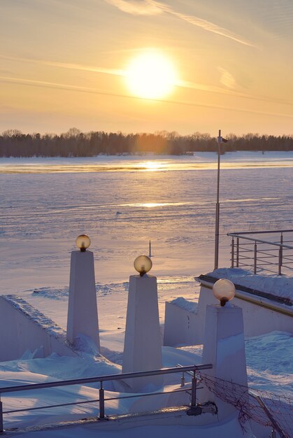 Winter embankment at sunset The parapet of the stairs with lighting poles