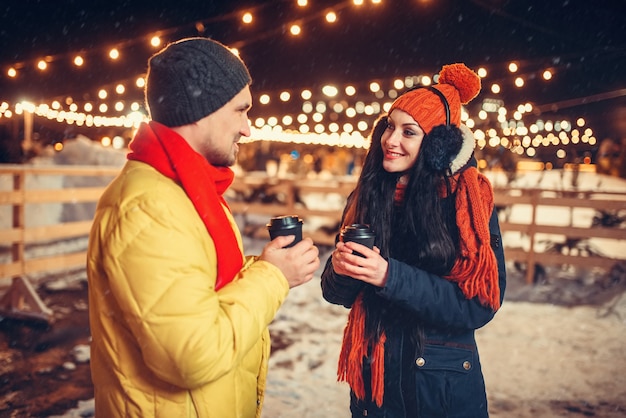 Sera d'inverno, coppia di innamorati beve caffè all'aperto