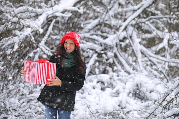 Winter fairy tale a young mother and her daughter ride a sled in the forest