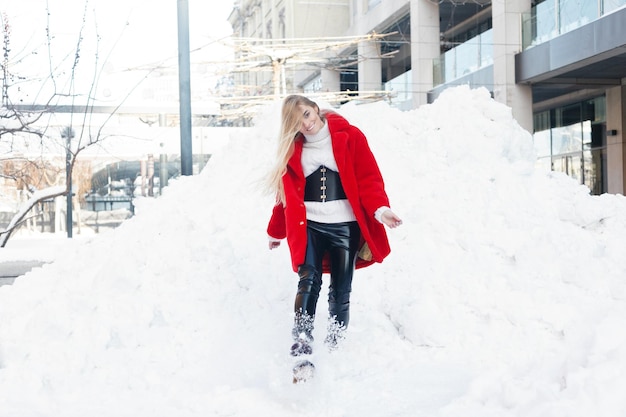 Winter, fashion, people concept - fashion Portrait of a beautiful young woman walks around the city smiling red fur coat close-up snowflakes cold winter, breathe fresh air at frost winter day. sunset