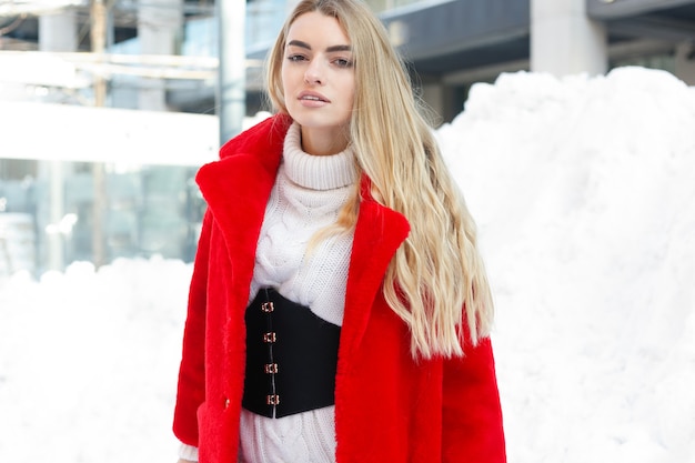 Winter, fashion, people concept - fashion Portrait of a beautiful young woman walks around the city smiling red fur coat close-up snowflakes cold winter, breathe fresh air at frost winter day