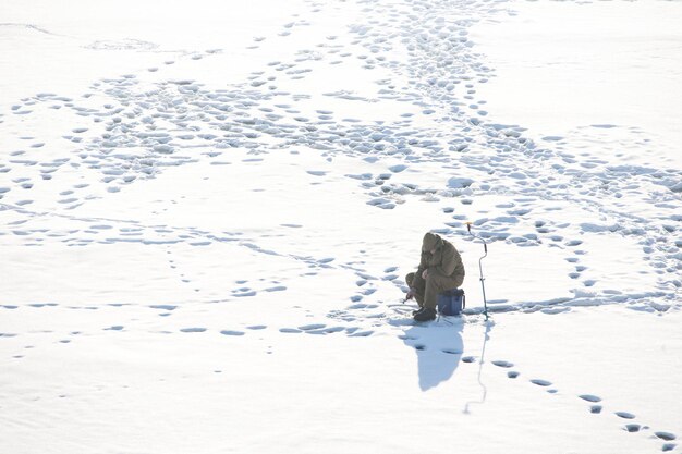 Winter fishing fisherman alone on snow