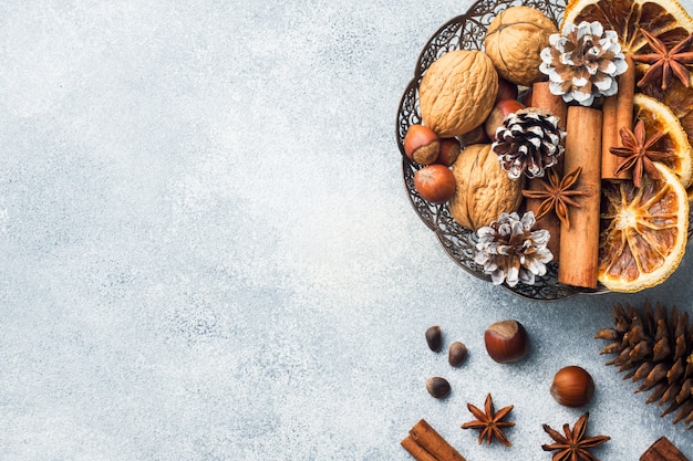 Photo winter food ingredients nuts cones oranges cinnamon star anise