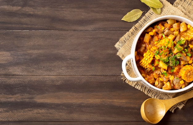 Winter food stew in bowl on burlap fabric copy space