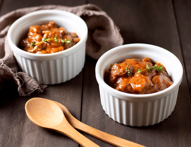 Winter food stew in bowl and wooden spoons