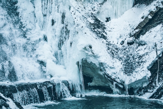 Photo winter frozen waterfall close up. ice and water