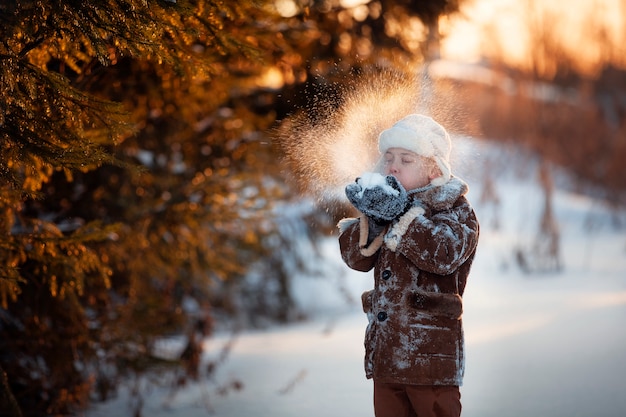 Fratelli di divertimento invernale giocano sulla neve e fanno un pupazzo di neve