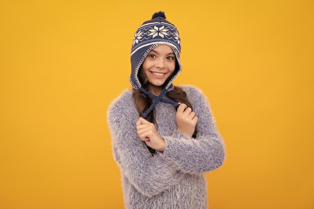 Winter hat cold season concept winter fashion accessory for\
children teen girl wearing warm knitted hat happy face positive and\
smiling emotions of teenager girl