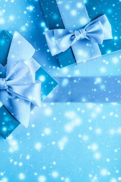 写真 冬のホリデー ギフトと凍った青の背景に輝く雪 クリスマス プレゼントの驚き