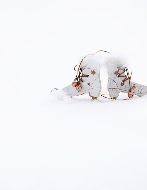 Winter holidays background:  wooden made skates in the snow. Closeup