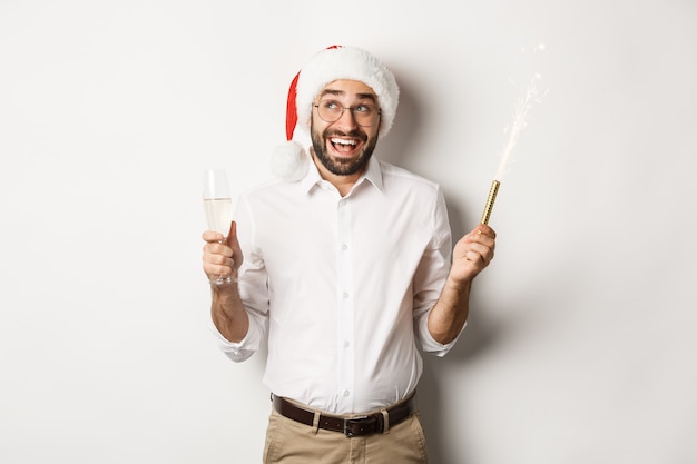 Winter holidays and celebration happy businessman enjoying new year party wearing santa hat and drin...