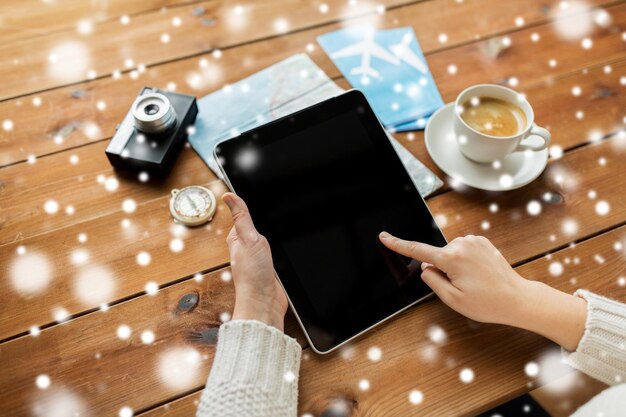 winter holidays, tourism, travel, technology and people concept - traveler hands with blank tablet pc computer and map over snow