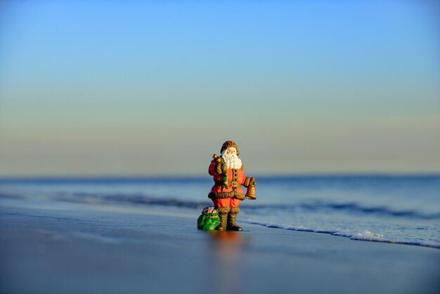 Winter on hot beach Christmas holiday concept Toy santa on the sea