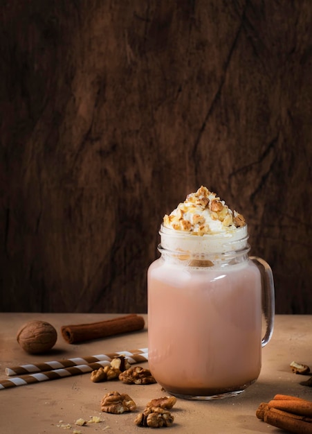 Photo winter hot dark chocolate with whipped cream and crushed walnuts in glass jar copy space