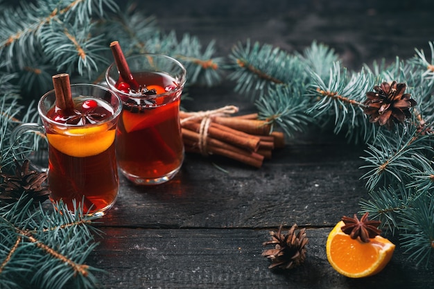 Winter hot drink Christmas mulled wine in glasses with anise, cinnamon and tangerine