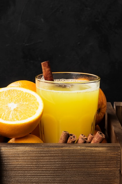 Winter hot drink from oranges and spices on black