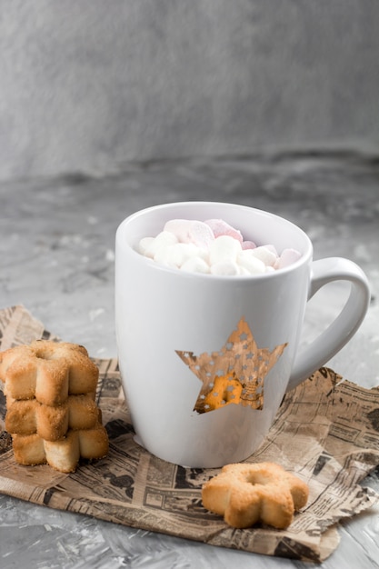 Winter hot drinks with cookies in a shape of stars on a shabby concrete graybackground