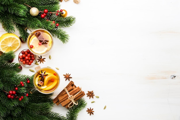 Tè caldo invernale con mirtilli rossi al limone e spezie per la sera di natale o capodanno sfondo bianco copia spazio vista dall'alto Foto Premium